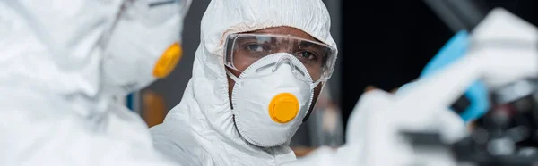 Panoramic shot of african american scientist looking at his colleague — Stock Photo