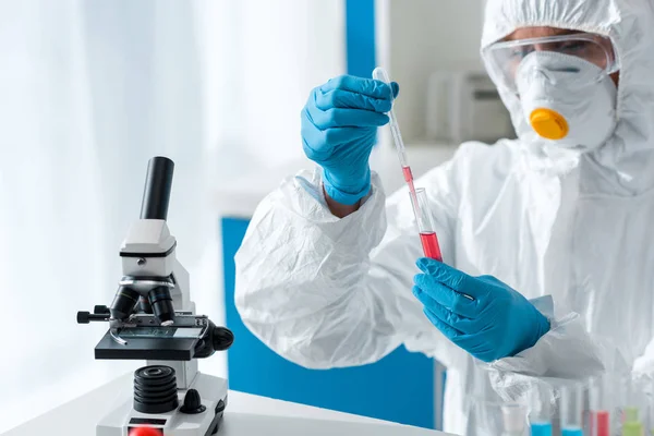 Científico en traje protector y guantes de látex haciendo prueba de ADN - foto de stock