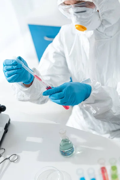 Cropped view of scientist in protective suit and latex gloves doing dna test — Stock Photo