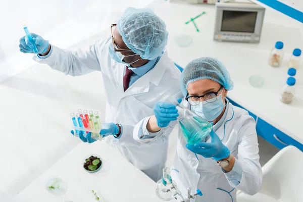 Vista aérea de biólogos multiculturales haciendo pruebas en laboratorio - foto de stock