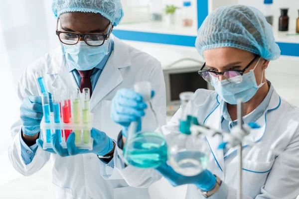 Foco seletivo de biólogos multiculturais fazendo teste em laboratório — Fotografia de Stock