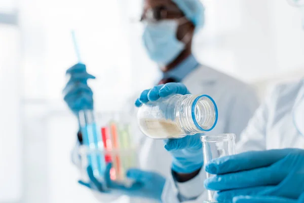 Selective focus of multicultural biologists doing test in lab — Stock Photo