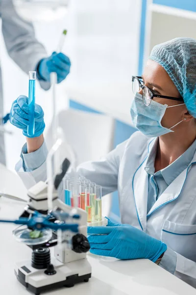 Selective focus of biologist looking at test tube in lab — Stock Photo