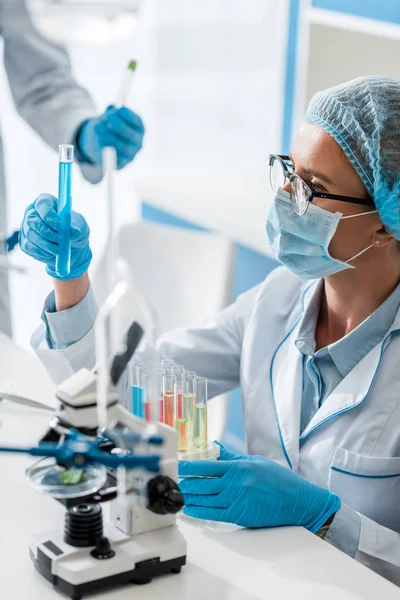 Foco seletivo do biólogo olhando para tubo de ensaio em laboratório — Fotografia de Stock