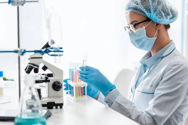 Vue latérale du biologiste regardant le tube à essai en laboratoire — Photo de stock