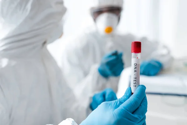 Selective focus of multicultural scientists looking at dna test — Stock Photo