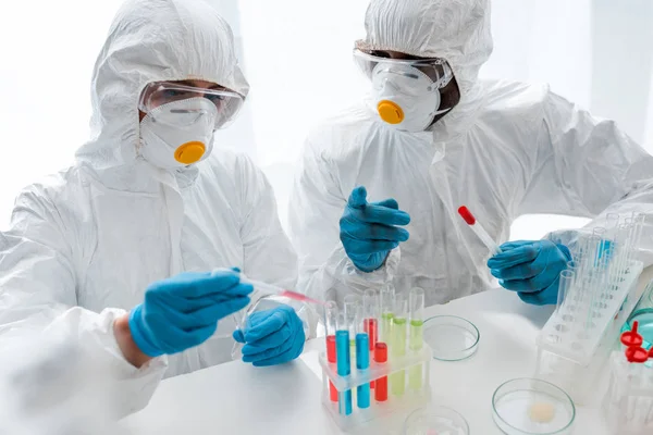 Cientistas multiculturais em trajes de proteção fazendo teste de dna em laboratório — Fotografia de Stock