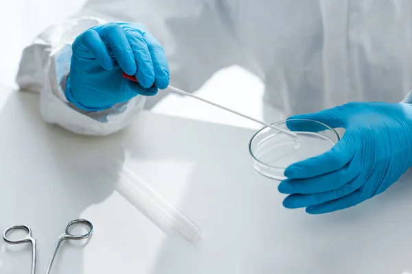 Обрезанный вид ученого в латексных перчатках, делающего тест ДНК в лаборатории — стоковое фото