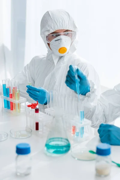 Vista recortada de los científicos en guantes de látex haciendo prueba de ADN en el laboratorio - foto de stock
