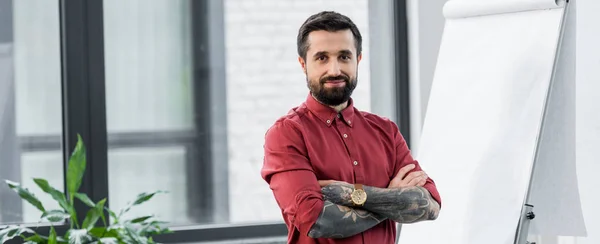 Prise de vue panoramique du gestionnaire de compte beau et souriant avec les bras croisés regardant la caméra — Photo de stock