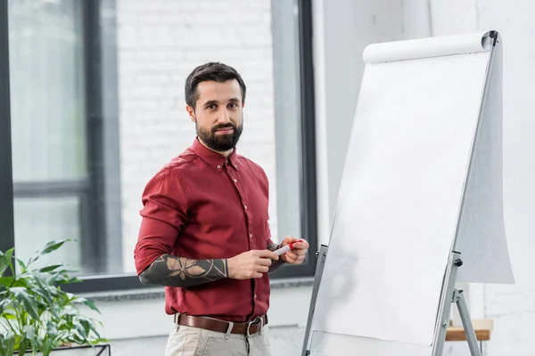 Beau gestionnaire de compte regardant la caméra dans le bureau — Photo de stock