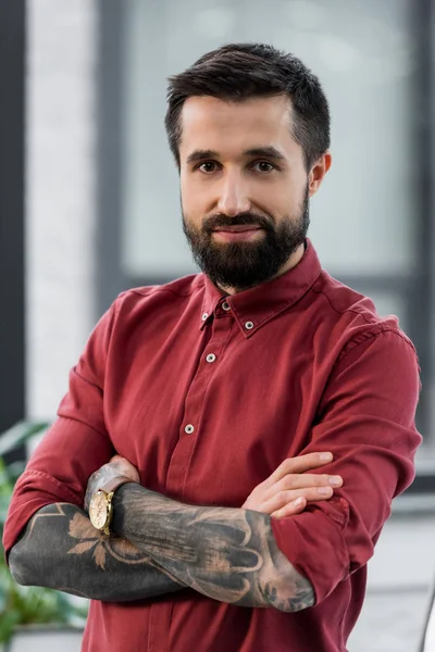 Bello e sorridente account manager con le braccia incrociate guardando la fotocamera — Foto stock