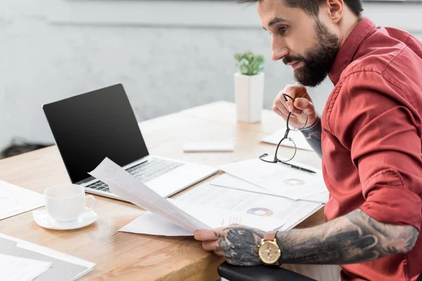 Vue recadrée du beau gestionnaire de compte assis à table et faisant de la paperasse — Photo de stock