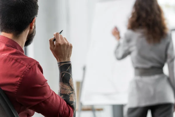 Selektive Fokussierung des Kontoführers auf seinen Kollegen in der Nähe des Flipcharts — Stockfoto