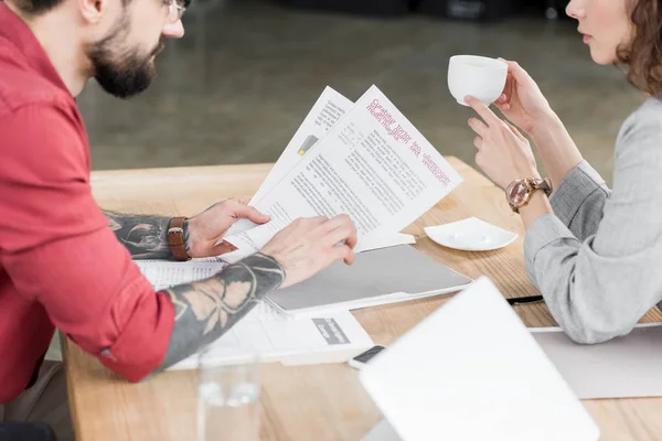 Abgeschnittene Ansicht von Kontoverwaltern, die Papierkram erledigen und Tasse halten — Stockfoto