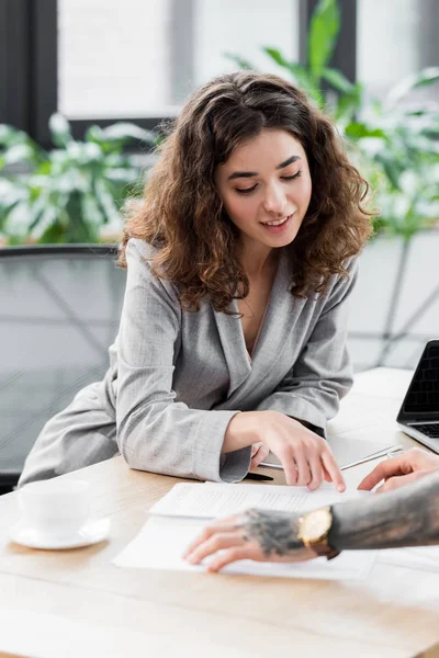 Smiling account manager pointing with finger at paper — Stock Photo