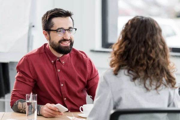 Selective focus of smiling account manager looking at colleague — Stock Photo