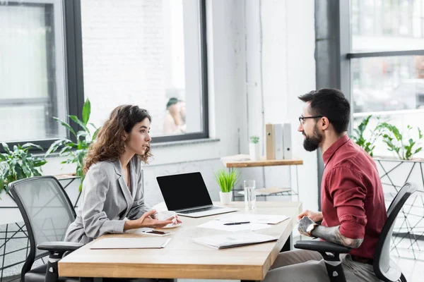 Vista laterale degli account manager che parlano e siedono a tavola — Foto stock