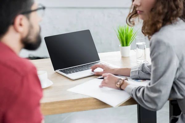 Vista recortada si los administradores de cuentas hablar y sentarse en la mesa - foto de stock