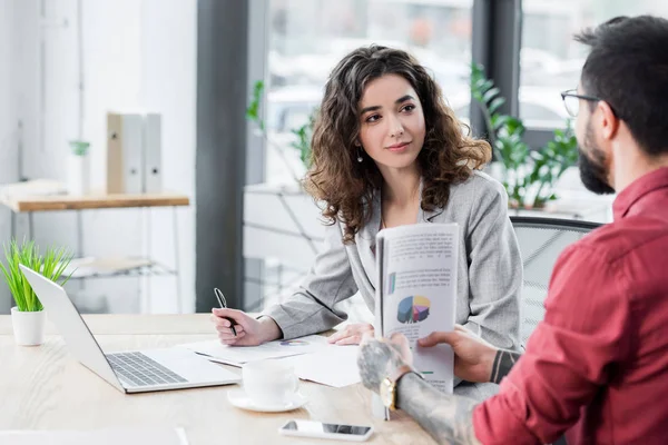 Account manager sitting at table and talking with colleague — Stock Photo