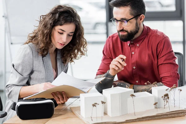 Virtual-Reality-Architekten sitzen am Tisch und erledigen Papierkram — Stockfoto