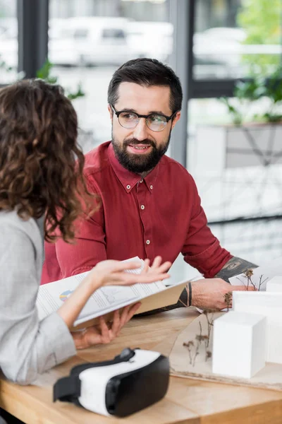Selective focus of smiling virtual reality architect talking with colleague — Stock Photo