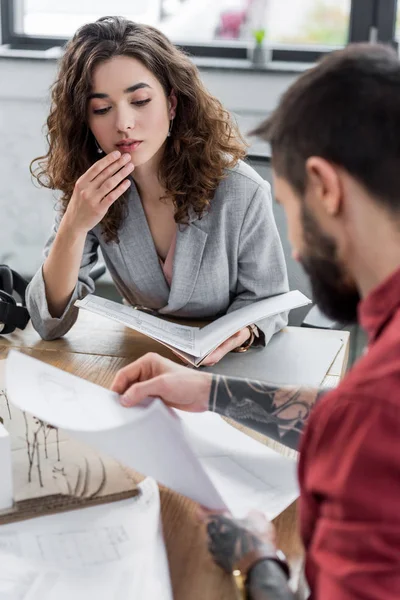 Selective focus of virtual reality architect doing paperwork and looking at colleague — Stock Photo