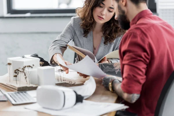 Foco seletivo do arquiteto de realidade virtual fazendo papelada com colega — Fotografia de Stock