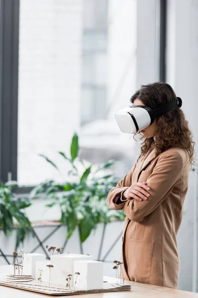 Vista lateral do arquiteto realidade virtual em fone de ouvido realidade virtual olhando para o modelo de casa — Fotografia de Stock