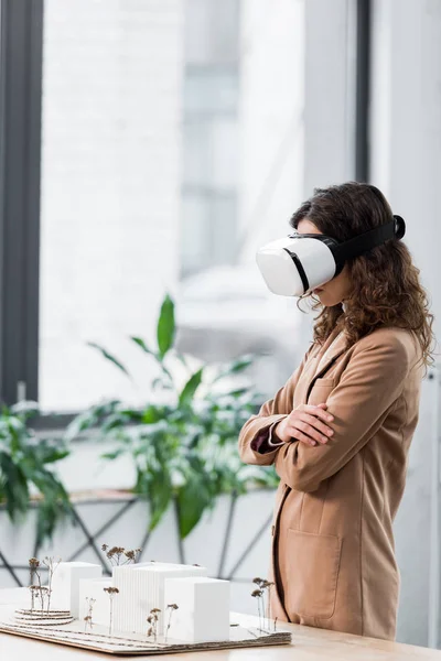 Vista lateral del arquitecto de realidad virtual en auriculares de realidad virtual mirando el modelo de casa — Stock Photo