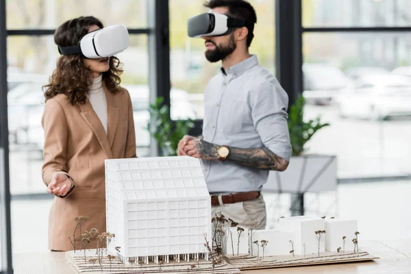 Virtual reality architects in virtual reality headsets talking in office — Stock Photo