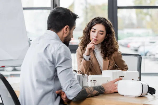 Pensive virtual reality architects looking at model of house — Stock Photo