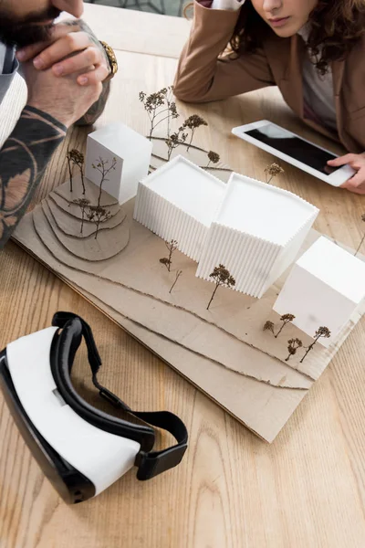 Cropped view of virtual reality architects looking at model of house — Stock Photo