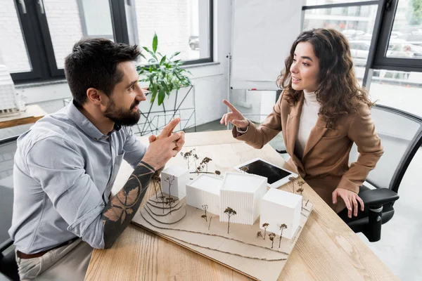 Smiling virtual reality architects sitting at table and talking in office — Stock Photo