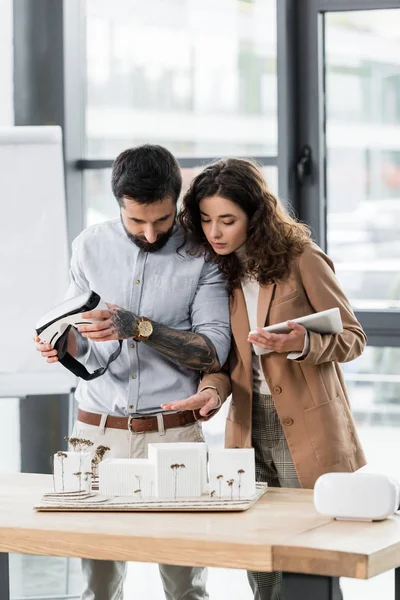 Virtual reality architects looking at model of house on table — Stock Photo