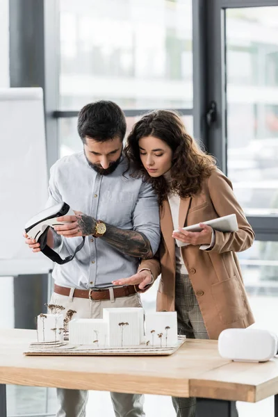 Arquitectos de realidad virtual mirando el modelo de casa en la mesa - foto de stock