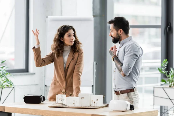 Arquitetos realidade virtual falando e de pé perto modelo de casa — Fotografia de Stock