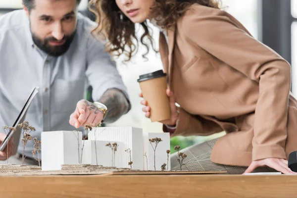 Cropped view of virtual reality architects pointing and looking at model of house — Stock Photo