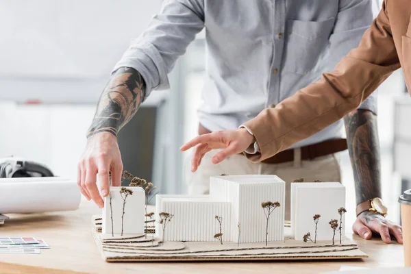 Cropped view of virtual reality architects pointing with finger at model of house — Stock Photo