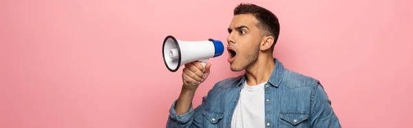 Panoramische Aufnahme von Mann schreit in Lautsprecher isoliert auf rosa — Stockfoto