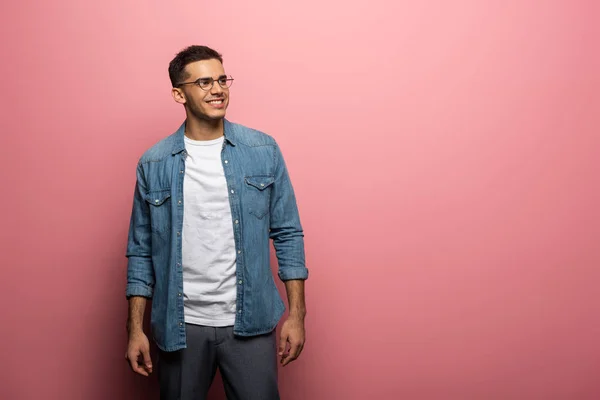 Handsome man smiling away on pink background with copy space — Stock Photo