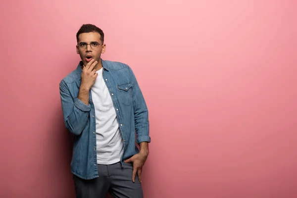 Excited man with nand by ching looking at camera on pink background — Stock Photo