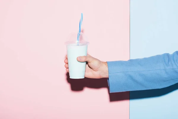 Cropped view of man holding cocktail on pink and blue background — Stock Photo