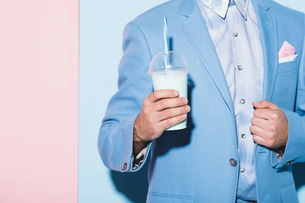 Vista ritagliata di uomo che tiene cocktail su sfondo rosa e blu — Foto stock