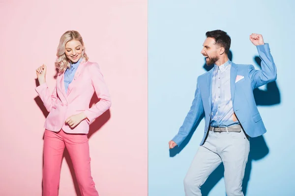 Smiling woman and handsome man showing yes gesture on pink and blue background — Stock Photo