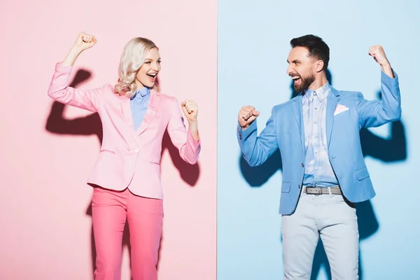 Sonriente mujer y guapo hombre mostrando sí gesto en rosa y azul fondo - foto de stock