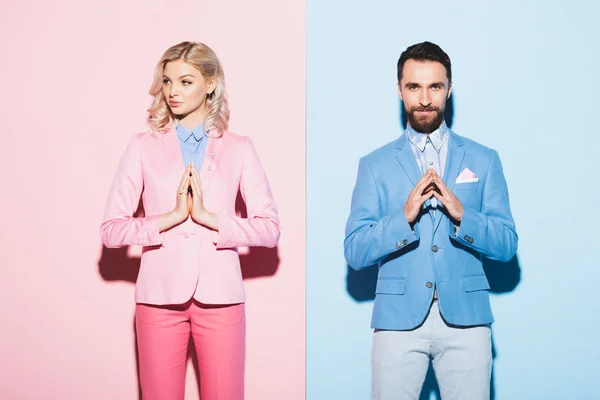 Attractive woman and smiling man with praying hands on pink and blue background — Stock Photo