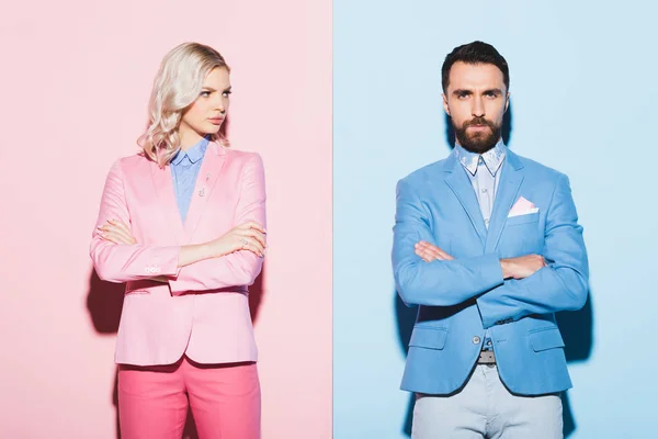 Femme triste et bel homme avec les bras croisés sur fond rose et bleu — Photo de stock