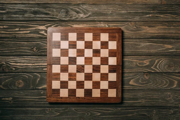 Top view of chessboard on wooden background — Stock Photo