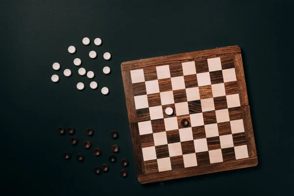 Вид зверху шашки з шашками ізольовані на чорному — стокове фото
